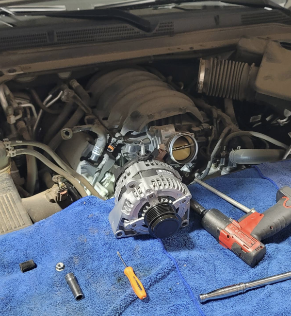 Técnico automotriz usando herramientas de diagnóstico para revisar un auto en Sánchez Auto Repair.
